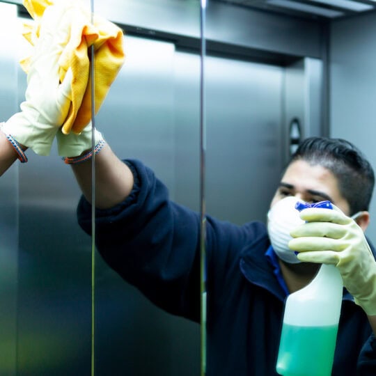 Building worker cleaning an elevator