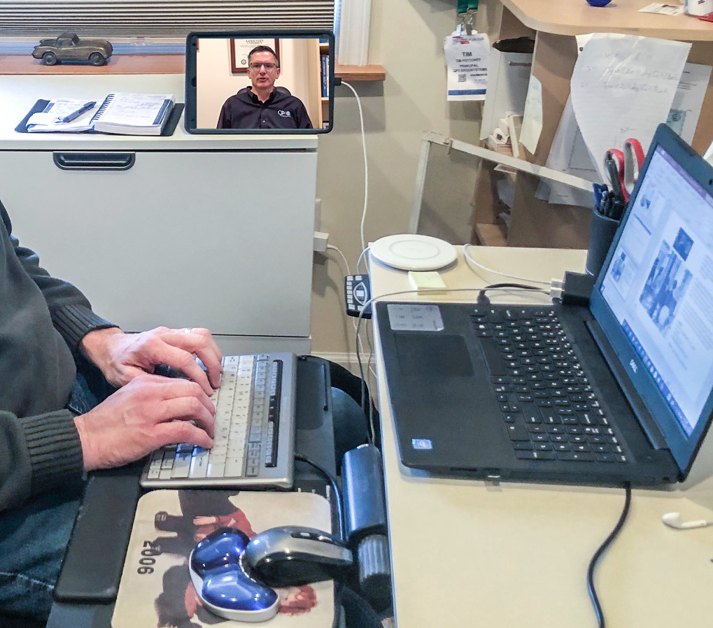 Workstation set up with mobile device propped for posture viewing.